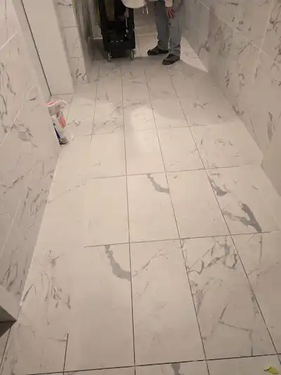 Finished polished flooring featuring large square white marble-effect porcelain tiles with grey veining